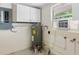 Utility room featuring a water heater, window AC, and storage cabinet at 734 Canal Rd, Sarasota, FL 34242