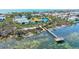 Scenic aerial view of the property featuring a pier, a pond, and lush landscaping, ideal for relaxation at 750 Bayport Way # 750, Longboat Key, FL 34228