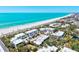 Aerial view of condos featuring lush landscaping and direct beach access to white sand and turquoise water at 750 Bayport Way # 750, Longboat Key, FL 34228