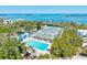 Aerial view featuring a community pool and tennis courts with beautiful landscaping and ocean views at 750 Bayport Way # 750, Longboat Key, FL 34228