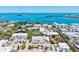 Real estate aerial view features luxurious bayfront condos, tennis courts, tropical landscaping and community parking at 750 Bayport Way # 750, Longboat Key, FL 34228