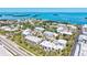 Aerial real estate photo features gorgeous waterfront property and condos with views of the bay and tropical foliage at 750 Bayport Way # 750, Longboat Key, FL 34228
