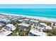 Aerial view of beachfront condos featuring lush landscaping and direct beach access to white sand and turquoise water at 750 Bayport Way # 750, Longboat Key, FL 34228