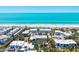 Beautiful aerial view showcases beach condos and a gorgeous beach with white sand, turquoise water, and sunny skies at 750 Bayport Way # 750, Longboat Key, FL 34228