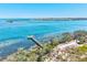 Aerial view of a pier extending into the ocean, with waterfront property surrounded by nature trails and trees at 750 Bayport Way # 750, Longboat Key, FL 34228