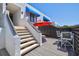 A view of the outdoor staircase leading to the modern deck with outdoor furniture at 750 Bayport Way # 750, Longboat Key, FL 34228