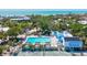 Aerial view highlighting the community pool and tennis courts, complemented by lush green surroundings at 750 Bayport Way # 750, Longboat Key, FL 34228