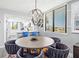 Dining area with modern chandelier and views of the updated kitchen and outdoors at 750 Bayport Way # 750, Longboat Key, FL 34228