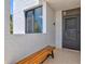A cozy entryway featuring a wooden bench, window, and dark entry door with textured walls at 750 Bayport Way # 750, Longboat Key, FL 34228