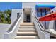 Exterior view of the building showing the staircase leading to the entrance with a blue awning at 750 Bayport Way # 750, Longboat Key, FL 34228