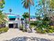 Charming building exterior showcasing tropical landscaping, covered parking, and a private entryway at 750 Bayport Way # 750, Longboat Key, FL 34228