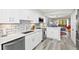 Well-lit kitchen featuring white cabinets, marble counters, stainless appliances and an open view of living space at 750 Bayport Way # 750, Longboat Key, FL 34228