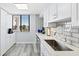 Bright kitchen featuring white cabinets, stainless steel sink, and a window with serene views at 750 Bayport Way # 750, Longboat Key, FL 34228
