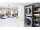Convenient laundry area with stacked washer and dryer units, along with shelving for storage at 750 Bayport Way # 750, Longboat Key, FL 34228