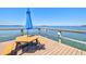 A picnic area on the pier, featuring a table, benches, and umbrella, overlooking a stunning water view at 750 Bayport Way # 750, Longboat Key, FL 34228