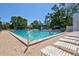 Resort-style pool area with lounge chairs, umbrellas, and lush tropical landscaping at 750 Bayport Way # 750, Longboat Key, FL 34228