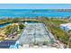 Aerial view highlighting tennis courts with ocean views, offering recreational opportunities for residents at 750 Bayport Way # 750, Longboat Key, FL 34228