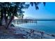 Scenic waterfront view with a picnic table, capturing the beauty of the serene water and distant bridge at 750 Bayport Way # 750, Longboat Key, FL 34228