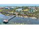 Aerial shot of a pier extending into the water, surrounded by lush vegetation and waterfront scenery at 750 Bayport Way # 750, Longboat Key, FL 34228