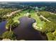 Panoramic aerial shot of the community golf course featuring a scenic lake, lush greenery, and sand traps at 7624 Boltons Ct, Bradenton, FL 34201