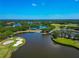 Aerial view of golf course community featuring lush landscaping, serene lakes, and stunning clubhouse at 7624 Boltons Ct, Bradenton, FL 34201