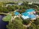 Stunning aerial view showcasing the clubhouse and well-manicured golf course with ponds and lush trees at 7624 Boltons Ct, Bradenton, FL 34201