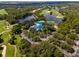 Breathtaking aerial view of the lush, green golf course, clubhouse, and tree-lined parking area at 7624 Boltons Ct, Bradenton, FL 34201