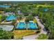 Aerial view of tennis and pickleball courts surrounded by lush greenery, and community amenities at 7624 Boltons Ct, Bradenton, FL 34201