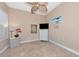 Neutral bedroom featuring tile floors, beach painting, and a ceiling fan at 7624 Boltons Ct, Bradenton, FL 34201