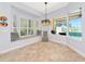 Bright breakfast nook features a window seat, designer lighting, and serene views of the pool at 7624 Boltons Ct, Bradenton, FL 34201