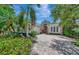 Elegant single-story home with lush landscaping, brick driveway, and a two-car garage at 7624 Boltons Ct, Bradenton, FL 34201