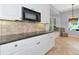 Stylish kitchen features granite countertops, white cabinets, and a bright breakfast nook at 7624 Boltons Ct, Bradenton, FL 34201