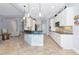 Open-concept kitchen with bar seating, tile floors, and updated appliances at 7624 Boltons Ct, Bradenton, FL 34201