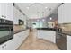 Spacious kitchen featuring white cabinets, granite countertops, and tile flooring at 7624 Boltons Ct, Bradenton, FL 34201