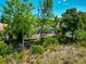 View of a screened-in pool area surrounded by lush greenery and trees, creating a private outdoor oasis at 7624 Boltons Ct, Bradenton, FL 34201