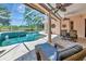 Lounge by the sparkling pool with covered patio, comfortable seating, and scenic backyard views at 7624 Boltons Ct, Bradenton, FL 34201