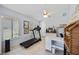 Bright bedroom with a ceiling fan, art, a treadmill, a desk, and neutral tiling at 8142 Misty Oaks Blvd, Sarasota, FL 34243