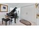 Elegant entryway featuring a grand piano, decorative glass block window, and storage closet at 8142 Misty Oaks Blvd, Sarasota, FL 34243