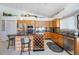 Bright kitchen featuring light wood cabinets, stainless steel appliances, and an island with bar seating, for cooking and entertaining at 8142 Misty Oaks Blvd, Sarasota, FL 34243