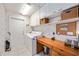 Functional laundry room with washer, dryer, built-in shelves, desk space, and neutral tiling at 8142 Misty Oaks Blvd, Sarasota, FL 34243