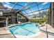 Screened-in pool with clear blue water and a seating area, providing a perfect spot for outdoor relaxation and entertainment at 8142 Misty Oaks Blvd, Sarasota, FL 34243