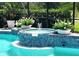 Inviting pool with a tiled jacuzzi and water feature, surrounded by lush greenery and providing a tranquil oasis at 8142 Misty Oaks Blvd, Sarasota, FL 34243