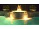 Night shot of the pool with an illuminated jacuzzi and water feature, creating a tranquil and inviting ambiance at 8142 Misty Oaks Blvd, Sarasota, FL 34243