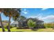 A home with a large screened-in patio surrounded by mature landscaping and a green lawn at 8142 Misty Oaks Blvd, Sarasota, FL 34243