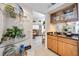 Stylish wet bar area with glass shelves, wooden cabinets, and a view into the adjacent kitchen at 8142 Misty Oaks Blvd, Sarasota, FL 34243