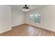 A minimalist bedroom with hardwood floors, bright natural light, and a modern ceiling fan with integrated lighting at 1016 38Th W St, Bradenton, FL 34205