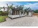 Side view of a well-maintained home showcasing the gravel yard, black trim, and white siding in a charming outdoor setting at 1016 38Th W St, Bradenton, FL 34205