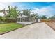Back view of a charming home with gravel driveway and black trim, set against a blue sky, evoking a welcoming atmosphere at 1016 38Th W St, Bradenton, FL 34205