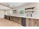 Kitchenette area with wood cabinets, shelves, mini-fridge, and stainless steel dishwasher at 1016 38Th W St, Bradenton, FL 34205