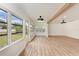 Spacious sunroom with wood floors and beam features an abundance of natural light, modern ceiling fans, and open living space at 1016 38Th W St, Bradenton, FL 34205